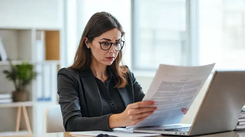 Una mujer confusa lee documentos legales