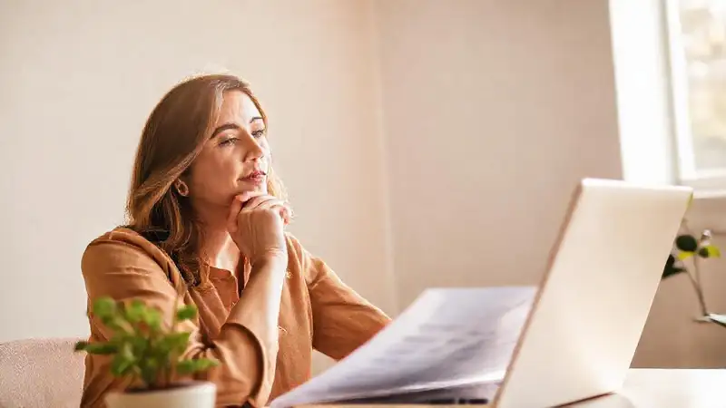Mujer analiza documentos con optimismo
